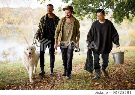 Men walk with dog and fishing equipment in nature 93728591