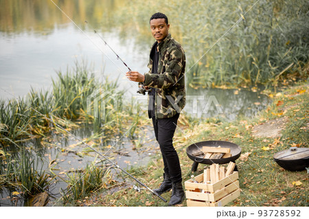 Man correct fishing rod at fishing on lake coast 93728592