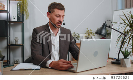 Businessman working on laptop wearing headset, call center support service operator office helpline 93729625