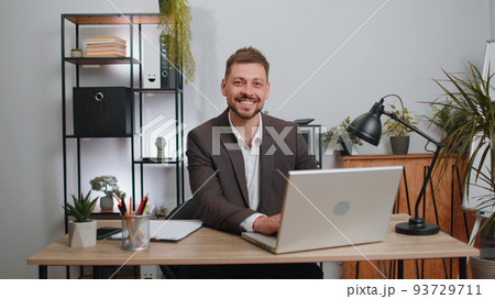 Businessman freelancer enters office workplace, working on laptop computer, sends online messages Businessman freelancer enters office workplace, working on laptop computer, sends online messages 93729711