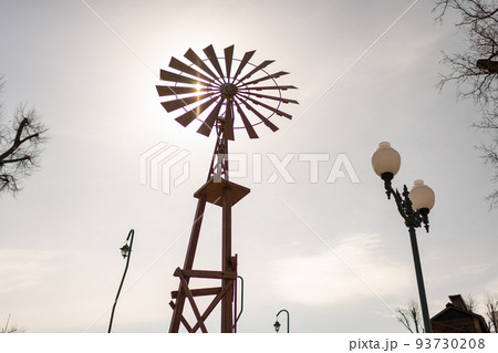 old wind turbine with blades on cloudy sky background 93730208
