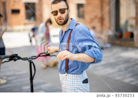 Portrait of a stylish guy with electric scooter outdoors Portrait of a stylish guy with electric scooter outdoors 93730253