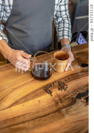 Professional barista serving a cafe customer at the counter Professional barista serving a cafe customer at the counter 93733119