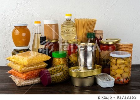 Emergency survival food set on dark wooden kitchen table 93733365
