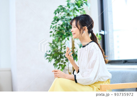 私服の若い女性　リビング　スマホ 93735972