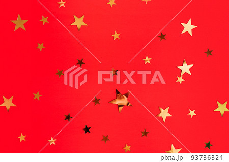 Golden stars glittering confetti on red background. Trendy festive holiday backdrop. Many star-shaped particles for a postcard, invintation or web banner. 2023 merry xmas backplate Golden stars glittering confetti on red background. Trendy festive holiday backdrop. Many star-shaped particles for a postcard, invintation or web banner. 2023 merry xmas backplate 93736324
