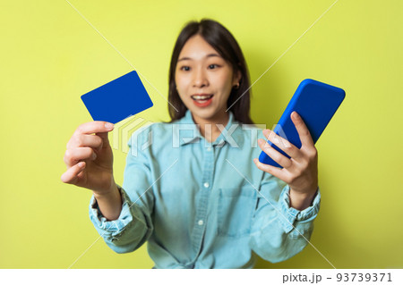 Korean Woman Using Smartphone And Credit Card Shopping, Yellow Background Korean Woman Using Smartphone And Credit Card Shopping, Yellow Background 93739371