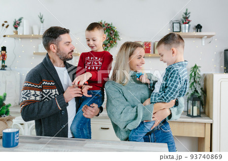 Cheerful happy married couple with two children waving hands laughing having fun at home for Christmas posing to camera indoor modern technology New Year congratulations to family or friends. 93740869