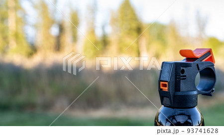Aerosol trigger of a can of bear spray in an outdoor setting 93741628