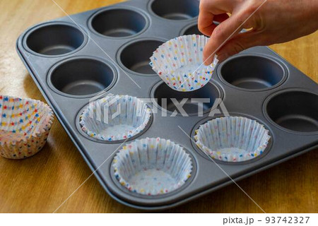 マフィンの紙カップをマフィン型にセットする 93742327