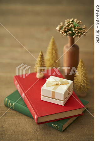 本に置かれたクリスマスプレゼントとミニチュアクリスマスツリー 93744385