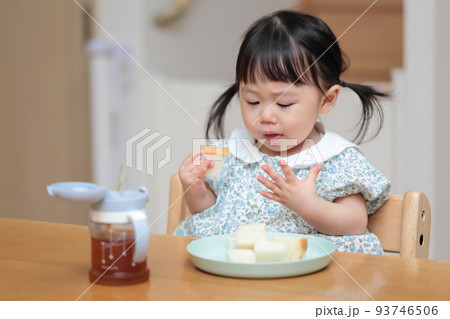 パンを手づかみ食べする1歳の女の子 93746506