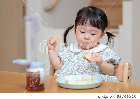パンを手づかみ食べする1歳の女の子 93746510