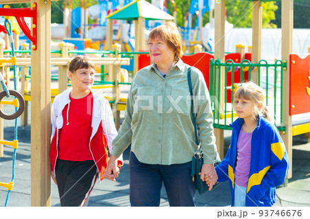 Grandmother with her young granddaughters outdoors Grandmother with her young granddaughters outdoors 93746676