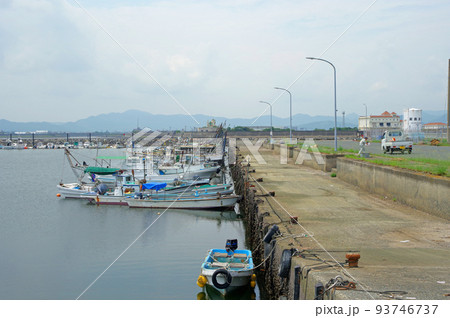 福岡県行橋市の蓑島漁港で水揚げ作業をする人と船 93746737
