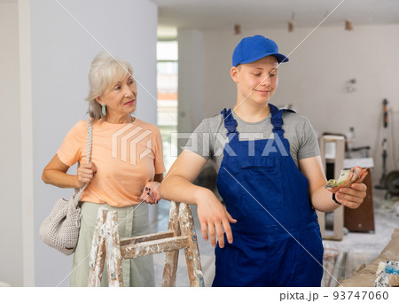 Satisfied young builder received money for his first job as house painter 93747060