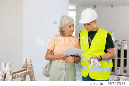 Teenager helping senior woman with home improvement works Teenager helping senior woman with home improvement works 93747343
