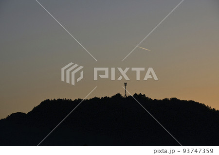 山に沈む夕日と電波塔 93747359
