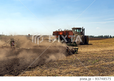 The tractor plows the land. Agriculture image. The tractor plows the land. Agriculture image. 93748575