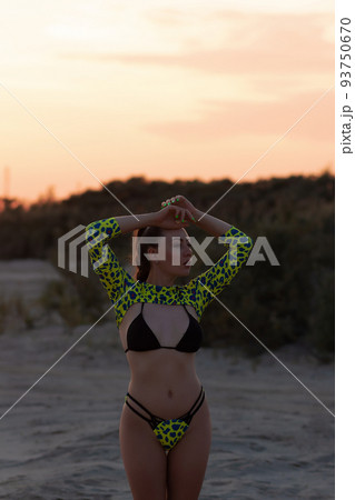 Sexual young woman in bikini admiring nature on sandy seashore Sexual young woman in bikini admiring nature on sandy seashore 93750670