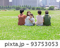 芝生の上に座る家族 93753053