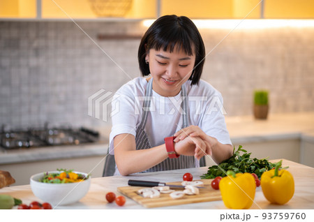 A girl in the kitchen preparing to cook something tasty 93759760