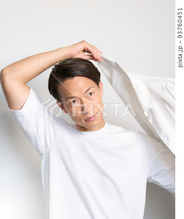 大きく手をあげながらYシャツに袖を通す男性 大きく手をあげながらYシャツに袖を通す男性 93760451