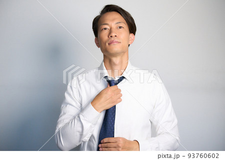 前を見てネクタイを整えるビジネスマン 前を見てネクタイを整えるビジネスマン 93760602