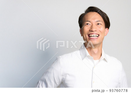 笑顔を見せる白いシャツを着た若い男性 93760778