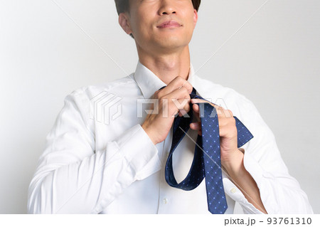 前を見ながらネクタイを結ぶビジネスマン 前を見ながらネクタイを結ぶビジネスマン 93761310