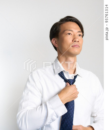 前を見てネクタイを整えるビジネスマン 93761314
