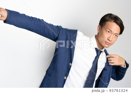 手を広げながら上着に袖を通すビジネスマン 93761324