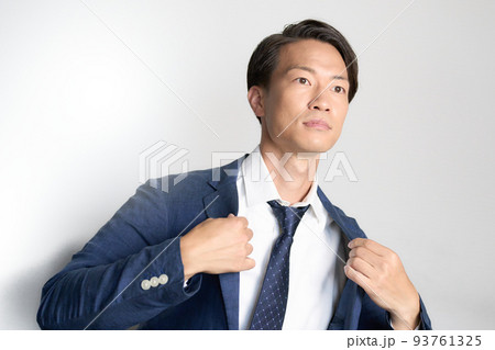 上着の襟を整えるビジネスマン 上着の襟を整えるビジネスマン 93761325