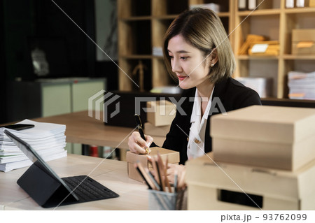 Shipping shopping online ,woman start up small business owner writing address on cardboard box at workplace.small business entrepreneur SME or freelance asian woman working with box at home. Shipping shopping online ,woman start up small business owner writing address on cardboard box at workplace.small business entrepreneur SME or freelance asian woman working with box at home. 93762099