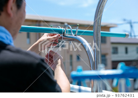 洗濯竿の固定をする男性 93762431