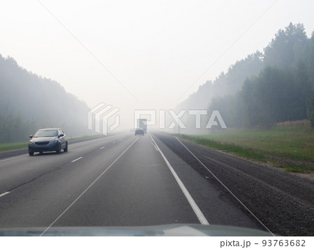 driving on highway in smoke from burning forest 93763682