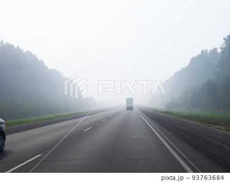 haze on road from burning forest smoke in morning 93763684