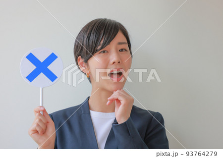 Xのプレートを持ち大きく口を開ける女性2 93764279