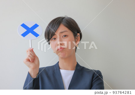 Xのプレートを持ちしかめっ面の女性2 93764281