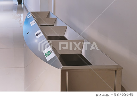 Modern steel litter bin with sections for sorting rubbish in public place inside Modern steel litter bin with sections for sorting rubbish in public place inside 93765649