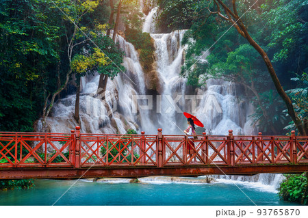 Woman walking at Kuang Si waterfall in Luang Prabang, Laos. Woman walking at Kuang Si waterfall in Luang Prabang, Laos. 93765870