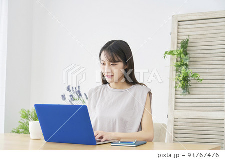 リビングでノートパソコンを使う女性 リビングでノートパソコンを使う女性 93767476