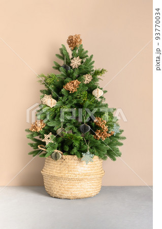 Christmas tree in wicker basket decorated with natural dry flowers and eco materials, DIY toys. Christmas tree in wicker basket decorated with natural dry flowers and eco materials, DIY toys. 93770034