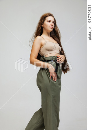 Portrait of young pretty girl with long hair posing isolated over gray studio background. Wellness, wellbeing, bodypositive, fashion concept. 93770355