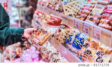 スーパーでソーセージを買う若い女性のイメージカット スーパーでソーセージを買う若い女性のイメージカット 93771776