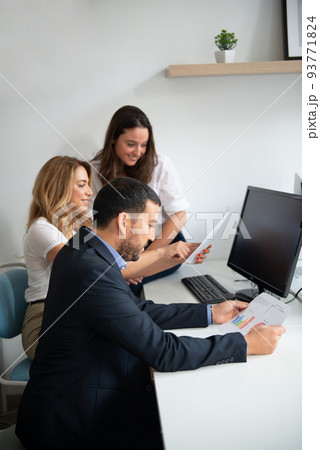 Business team of men and women in an office analyzing the evolution of the company Business team of men and women in an office analyzing the evolution of the company 93771824