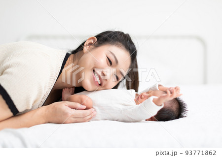 Beautiful Attractive Asian mom listening on baby belly sweet and lovely. Happy mother and infant baby looking together smile good moment with love. Mother and baby newborn Concept Beautiful Attractive Asian mom listening on baby belly sweet and lovely. Happy mother and infant baby looking together smile good moment with love. Mother and baby newborn Concept 93771862