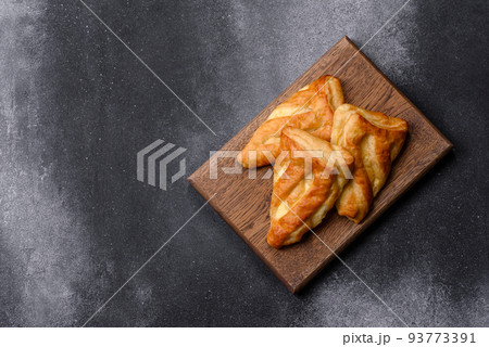 Delicious fresh cornmeal pastries with homemade cheese on a wooden cutting board Delicious fresh cornmeal pastries with homemade cheese on a wooden cutting board 93773391