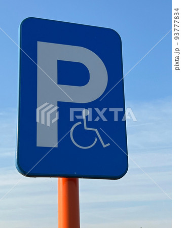 Vertical shot on a blue panel for reserved parking spots for disabled people Vertical shot on a blue panel for reserved parking spots for disabled people 93777834
