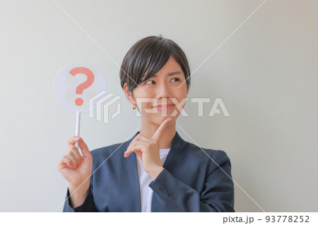 はてなのプレートを持ちにこやかに考える女性2 はてなのプレートを持ちにこやかに考える女性2 93778252
